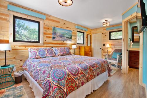a bedroom with a bed in a room with wooden walls at Deer Mountain Lodge North in Estes Park