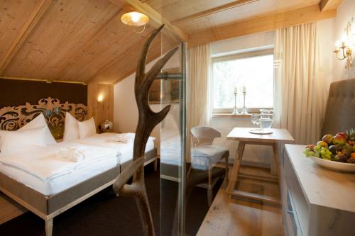 a bedroom with a bed and a table with a bowl of fruit at Minglers Sportalm - Das Gourmet- und Genießerhotel in Kirchberg in Tirol