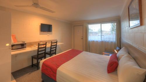 a hotel room with a bed, table and a television at Boonah Motel in Boonah