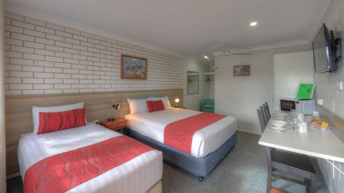 a hotel room with two beds and a desk at Boonah Motel in Boonah