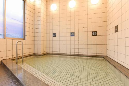 La salle de bains est pourvue d'une douche avec une piscine d'eau. dans l'établissement Hotel Uneri, à Okinoshima
