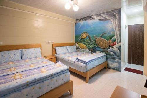 1 dormitorio con 2 camas y un cuadro en la pared en Yu Jing 6.8, en Xiaoliuqiu