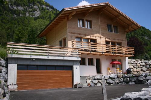 a house with a garage in front of it at Chalet Mack in Brienzwiler