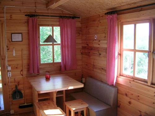 - une salle à manger avec une table en bois et 2 fenêtres dans l'établissement Chalet, à Myza Igaste
