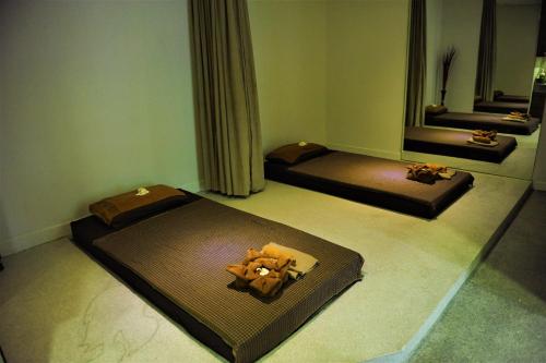 a room with three beds and a mirror at Bopha Bassac Boutique Hotel in Phnom Penh