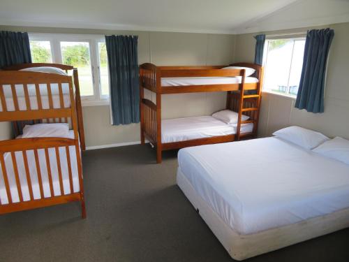 a bedroom with two bunk beds and a window at Whanganui Seaside Holiday Park in Whanganui