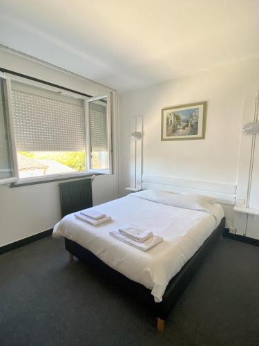 a bedroom with a large bed with towels on it at Hotel du Centre Lucé Chartres in Luce