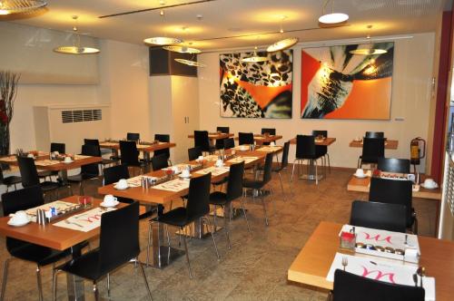 a dining room with wooden tables and chairs at Hotel Mercure Milano Solari in Milan