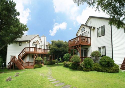 a large white house with a large yard at UTS Village in Jeju