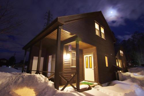 a small house in the snow at night at Villa Komakusa in Hakuba
