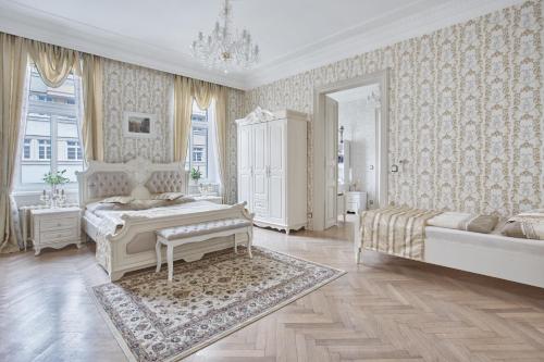 a white bedroom with a bed and a large window at Apartment Luxury Nostalgia in Karlovy Vary