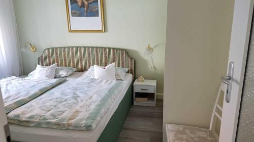 a small bedroom with a bed with white sheets at Ferienwohnung Riemeyer in Lutherstadt Wittenberg