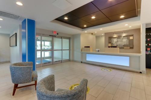 a lobby with two chairs and a large projection screen at Holiday Inn Express Hotel & Suites Corbin by IHG in Corbin