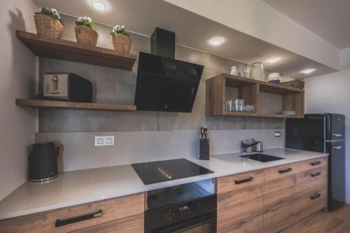 a kitchen with wooden cabinets and a black refrigerator at Apartman Central Ski & Bike in Janske Lazne