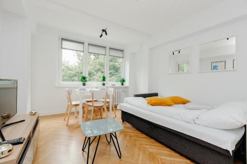 ein weißes Zimmer mit einem Bett, einem Tisch und Stühlen in der Unterkunft ShortStayPoland Jana Pawła (B27) in Warschau
