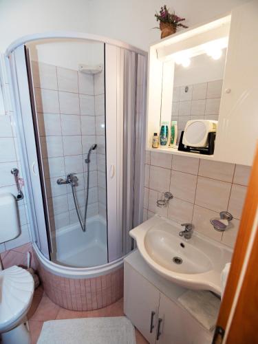 a bathroom with a shower and a sink at M. DE DOMINISA 5 in Rab
