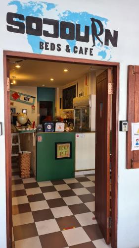 
a kitchen with a sign on the door of it at Sojourn Beds & Cafe in Taiping
