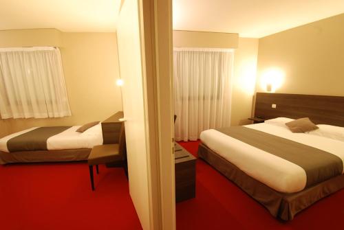 two beds in a hotel room with red carpet at Le Robinson in Saint-Jean-de-Monts