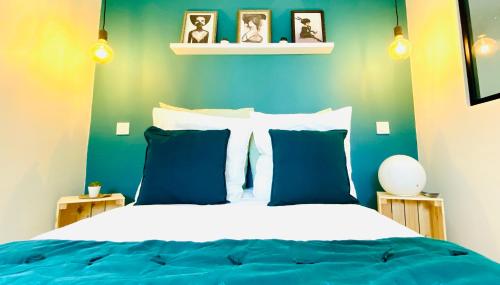 a bedroom with a bed with blue and white pillows at EL COCOONING - Apt entier WiFi Centre-Ville Proche Basilique in Lisieux