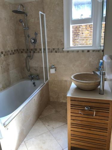 a bathroom with a tub and a sink and a shower at Kew Gardens & National Archives in Richmond upon Thames