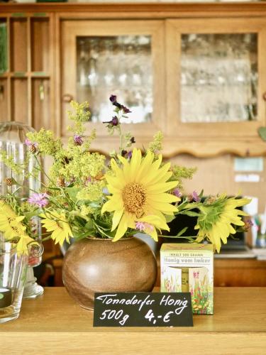 a vase filled with yellow flowers on a table at Pension Grünes Herz in Tonndorf
