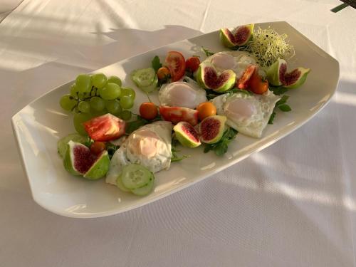 a plate of food with fruit and vegetables on a table at Rooms & Pansion Odmor in Rovanjska