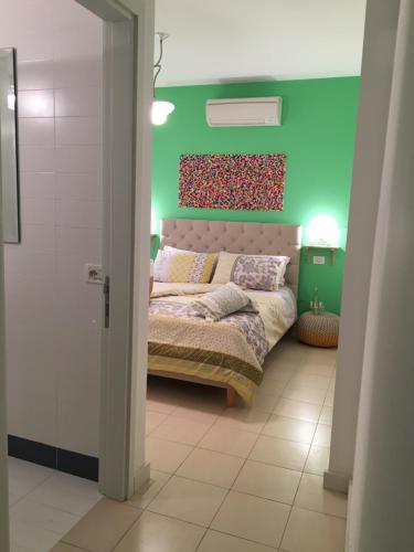 sypialnia z łóżkiem i zieloną ścianą w obiekcie Intra Rooms w mieście Olbia