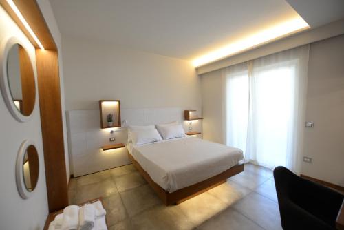 sypialnia z białym łóżkiem i oknem w obiekcie B&B Maestrale w Tropei