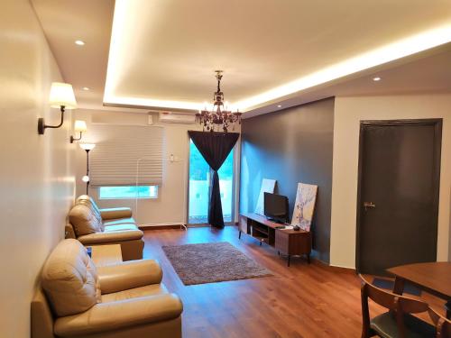 a living room with couches and a television and a table at D'Ocean Homestay in Tiara Desaru Residence in Desaru