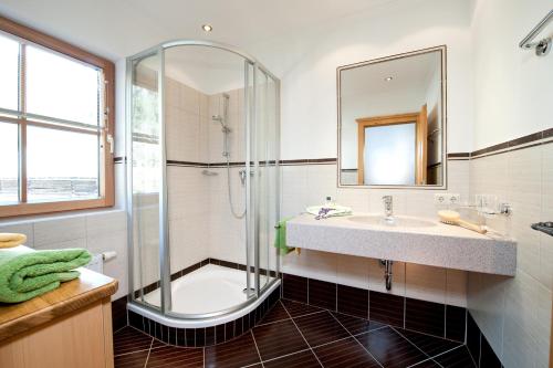 a bathroom with a shower and a sink and a mirror at Brandebengut in Bad Hofgastein