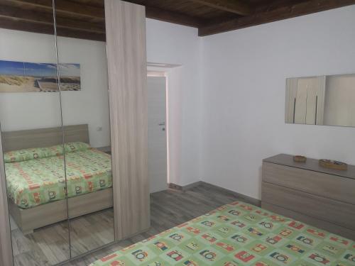 a bedroom with a bed and a mirror at Casa Dema climatizzata con wifi in Martis