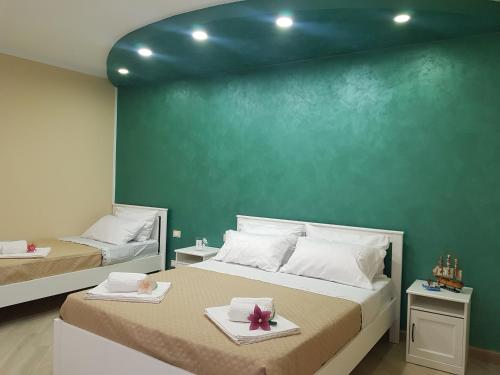 1 dormitorio con 2 camas y pared verde en Rigoletto, en Campofelice di Roccella