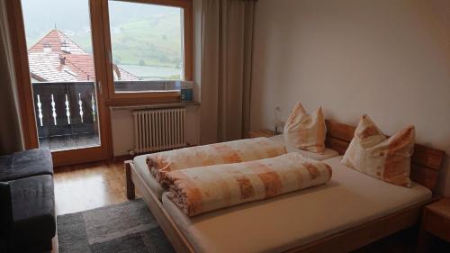 a bedroom with a bed with a large window at Pension Tirol in San Valentino alla Muta