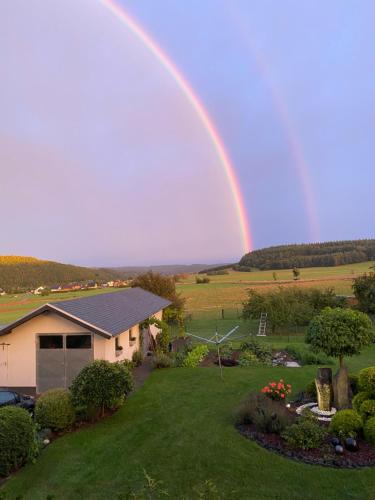 a rainbow over a house with a yard at Pension Görgen in Herresbach