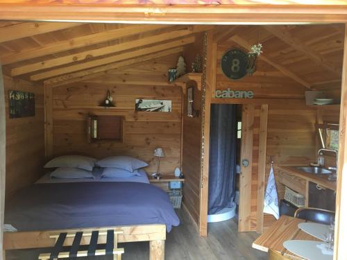 una camera con un letto in una baita di tronchi di la Cabane dans les Arbres a Saint-Jean-d'Aulps