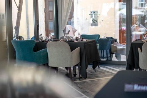 a dining room with a black table and chairs at Bed and Brekfast Donatella in Piran