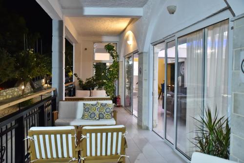 a porch with a couch and chairs on a balcony at Bali Mare Village in Balíon