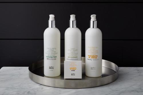 three white bottles sitting on a metal tray at Kimpton Hotel Arras by IHG in Asheville