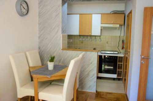 una piccola cucina con tavolo, sedie e piano cottura di Dunavski Kej a Smederevo