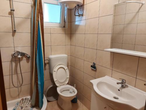 małą łazienkę z toaletą i umywalką w obiekcie Apartments Sunrise w mieście Pirovac