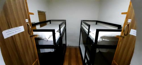 three bunk beds in a room with a door at Comfort Stay Hostel in New Delhi