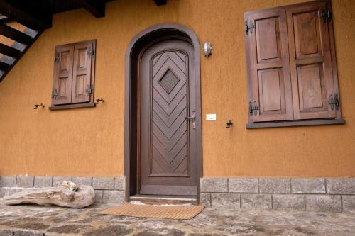 een huis met een bruine deur en twee ramen bij Teola in Livigno