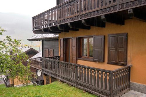 a balcony of a house with wooden doors and windows at Teola in Livigno
