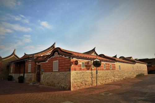 um edifício com uma cerca em frente em 金門古寧歇心苑官宅古厝民宿 Guning Xiexinyuan Historical Inn em Jinning