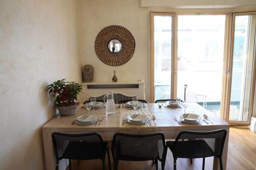 uma mesa de jantar com cadeiras e uma grande janela em Large 5 rooms with garage in the city center em Annecy