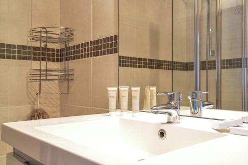 y baño con lavabo blanco y espejo. en Appartement l'Opale - T2 48m avec parking à 300m du Lac d'Annecy, en Annecy