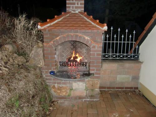 a brick oven with a fire in it at Ferienhaus Haus am Wald in Stolberg i. Harz