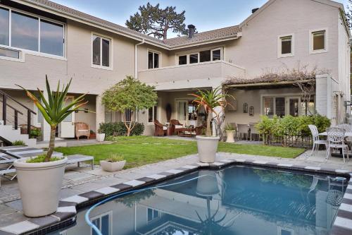 a house with a swimming pool in front of a house at Hermanus Lodge on the Green - Solar Power in Hermanus