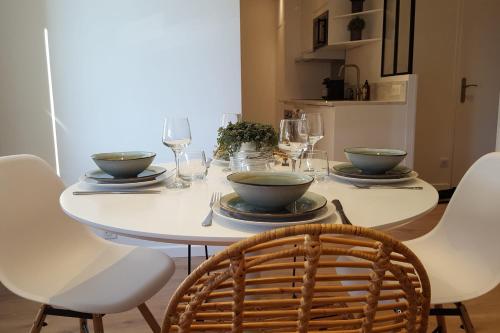 - une table à manger avec des bols et des assiettes dans l'établissement La Roseraie - Apartment 100m from Lake Annecy, à Annecy