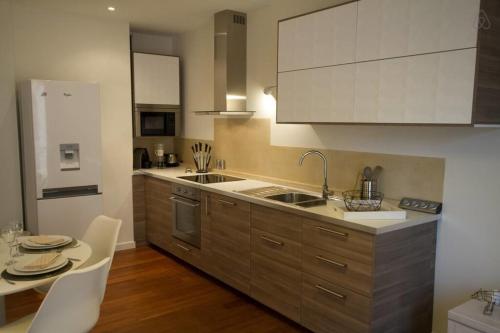 a kitchen with white cabinets and a table and chairs at Pretty 3 rooms in the city center in Annecy